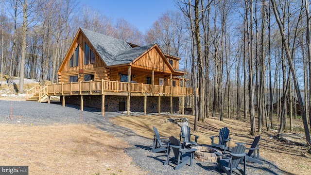 rear view of house featuring a deck and a fire pit