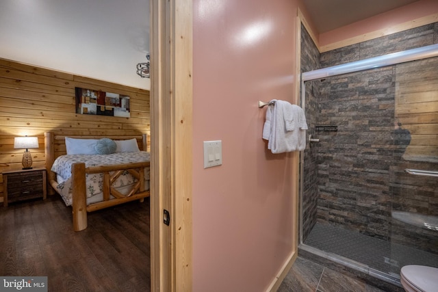 bedroom with dark hardwood / wood-style flooring and wood walls