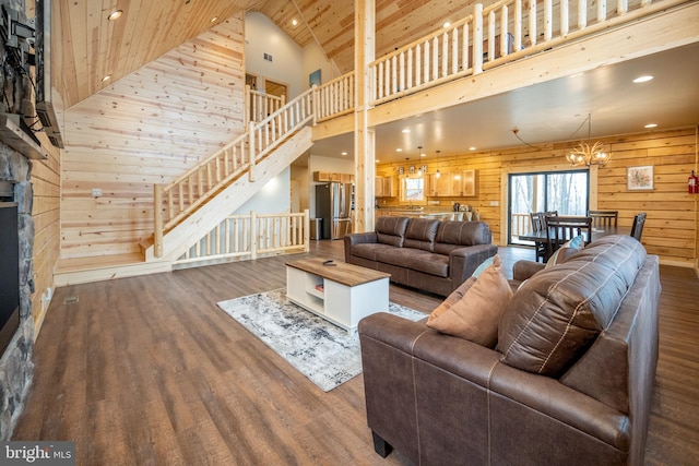 living room with an inviting chandelier, hardwood / wood-style floors, wood ceiling, high vaulted ceiling, and wooden walls