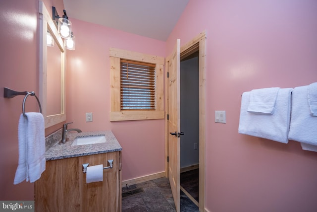 bathroom featuring tile flooring, vanity, and lofted ceiling