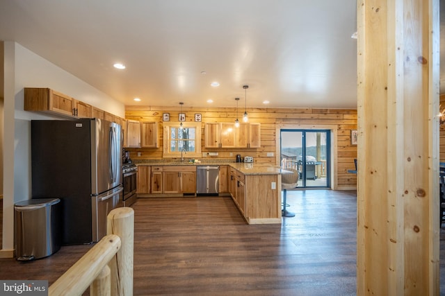 kitchen with a healthy amount of sunlight, dark hardwood / wood-style floors, and pendant lighting