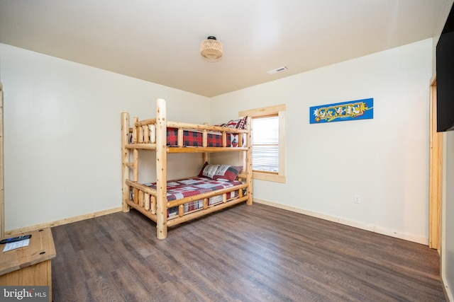 bedroom with dark hardwood / wood-style floors