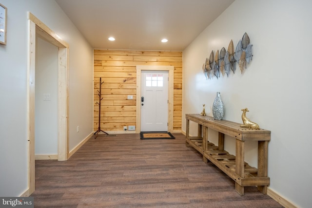 entryway with dark wood-type flooring and wooden walls