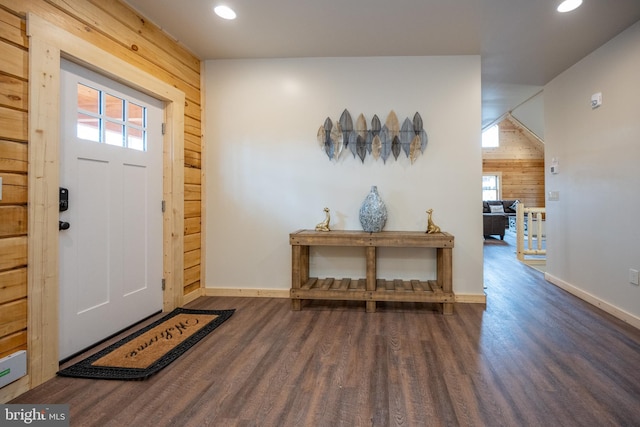 foyer entrance with hardwood / wood-style floors and wood walls