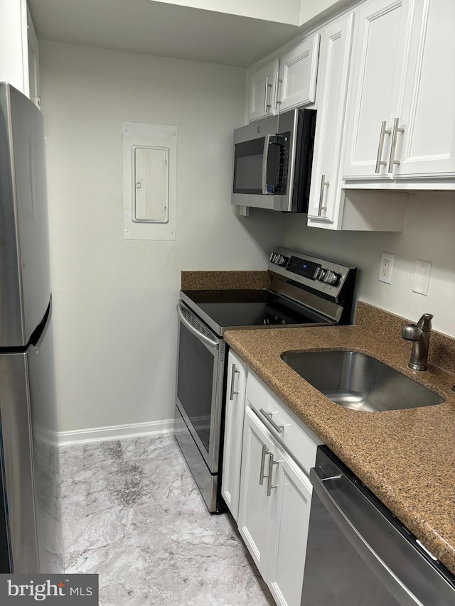 kitchen with dark stone counters, stainless steel appliances, sink, white cabinets, and electric panel