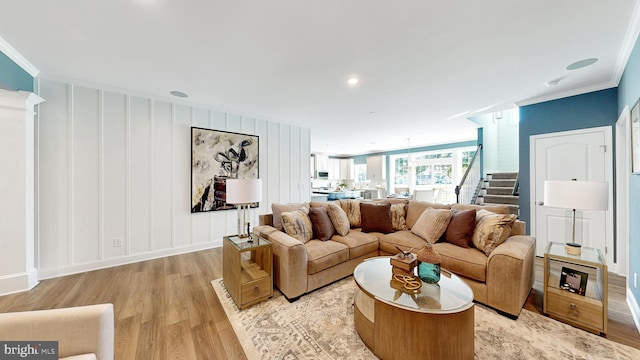 living room with ornamental molding and light hardwood / wood-style flooring