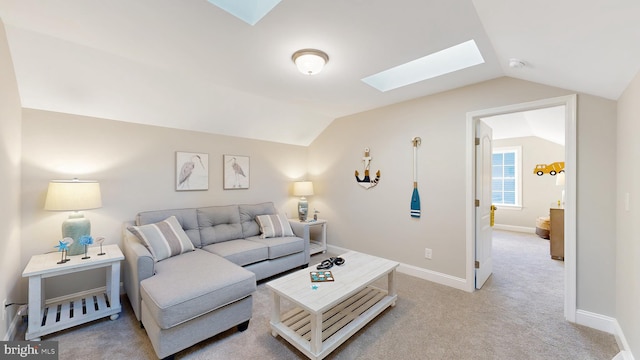 carpeted living room with vaulted ceiling with skylight