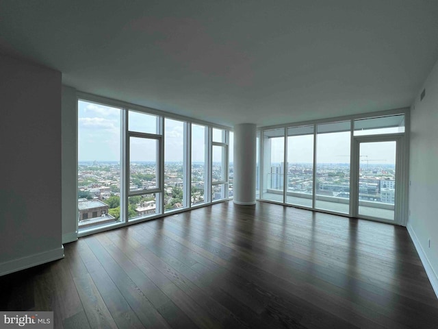 unfurnished room featuring dark hardwood / wood-style floors and a wall of windows