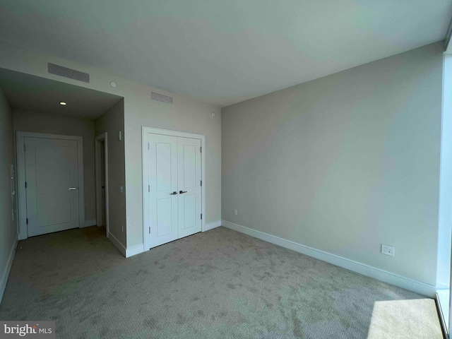 unfurnished bedroom featuring carpet flooring and a closet