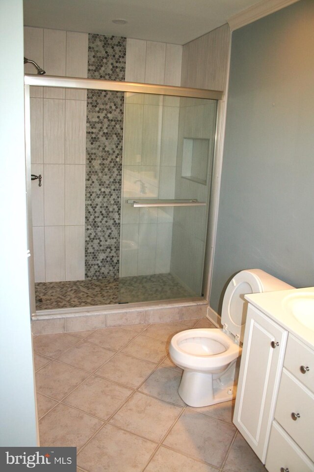 1707 Bay St, Fenwick Island, DE 19944 - bathroom with ornamental molding, toilet, vanity, tile patterned floors, and a stall shower