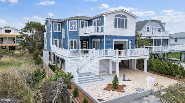 1707 Bay St, Fenwick Island, DE 19944 - rear view of property with a carport, concrete driveway, stairway, and a balcony