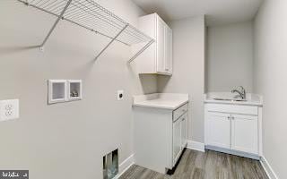 laundry area featuring hookup for an electric dryer, dark hardwood / wood-style floors, cabinets, and sink