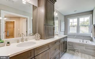 bathroom featuring tiled bath and vanity