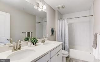 full bathroom with vanity, shower / tub combo, and toilet