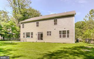 rear view of house featuring a yard