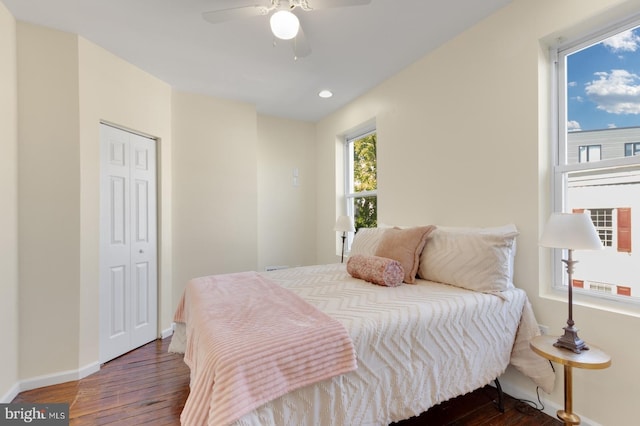 bedroom featuring dark wood-type flooring, ceiling fan, and a closet