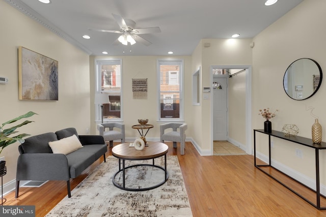 living room featuring ceiling fan, light hardwood / wood-style flooring, and a barn door