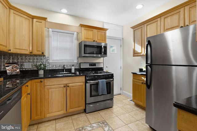 kitchen featuring tasteful backsplash, sink, stainless steel appliances, dark stone countertops, and light tile patterned floors