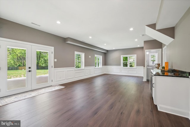 unfurnished living room featuring a wealth of natural light, dark hardwood / wood-style flooring, and french doors