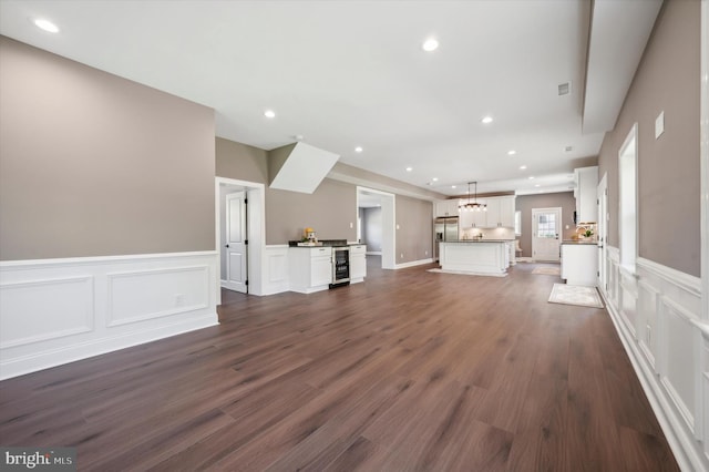 unfurnished living room featuring dark wood-type flooring and wine cooler