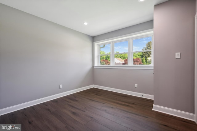 spare room featuring dark wood-type flooring