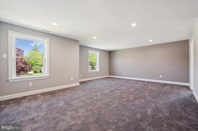 unfurnished room featuring dark colored carpet