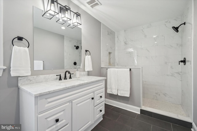 bathroom with a tile shower, tile floors, and vanity