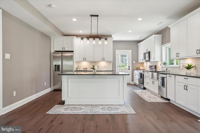 kitchen with stainless steel appliances, dark hardwood / wood-style flooring, backsplash, and pendant lighting