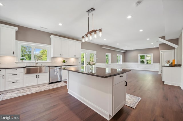 kitchen featuring a healthy amount of sunlight, sink, a kitchen island, and stainless steel dishwasher