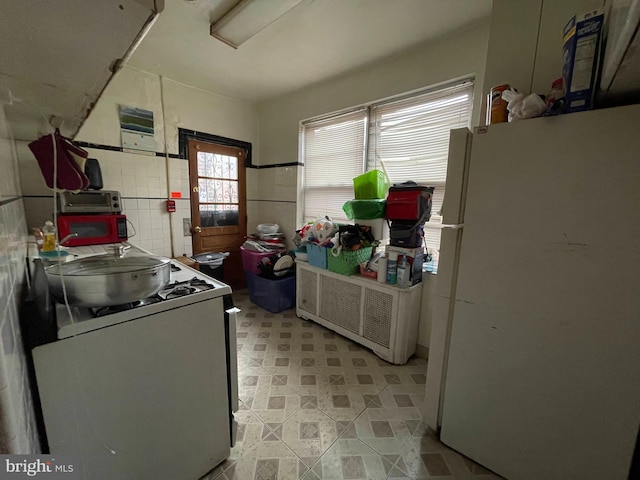 kitchen with white appliances and light tile flooring