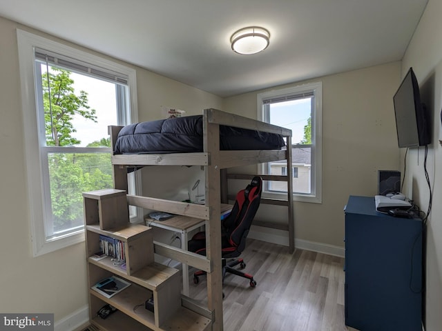 bedroom with multiple windows and light wood-type flooring