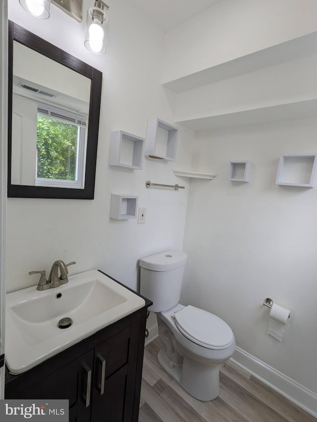 bathroom with hardwood / wood-style floors, vanity, and toilet