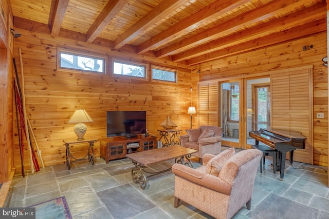 living area with stone tile flooring, beamed ceiling, and wood walls