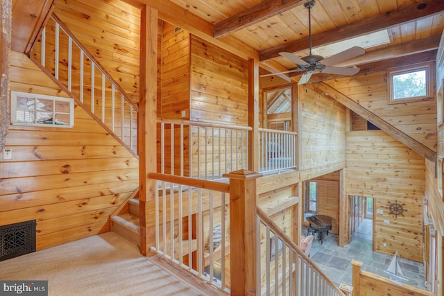 staircase featuring wooden ceiling, visible vents, wooden walls, and beam ceiling