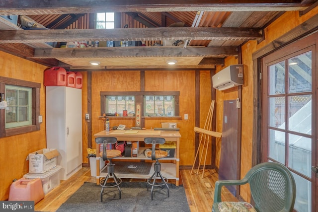 dining room with light wood-style floors, wooden walls, beam ceiling, and an AC wall unit