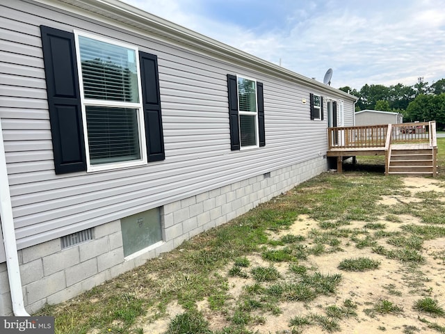 view of side of property featuring a wooden deck and a yard