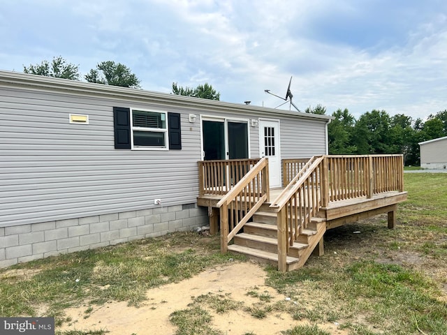 rear view of house with a wooden deck and a yard