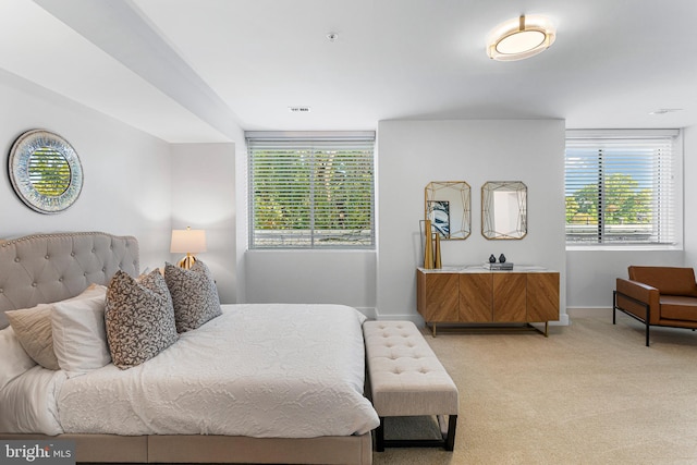 bedroom featuring light carpet and multiple windows