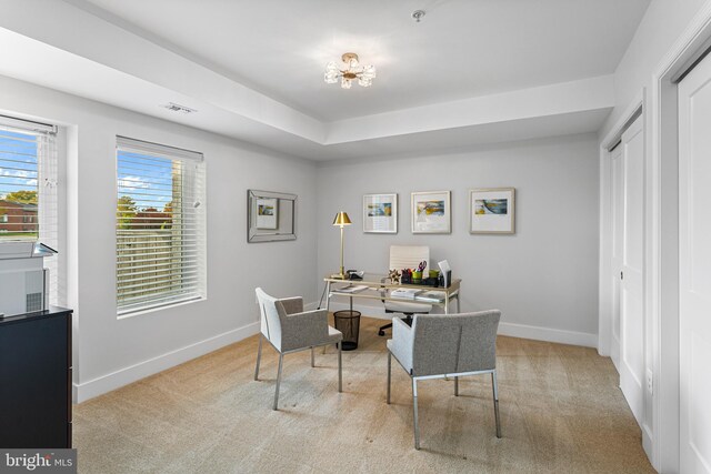 home office with light colored carpet and a notable chandelier