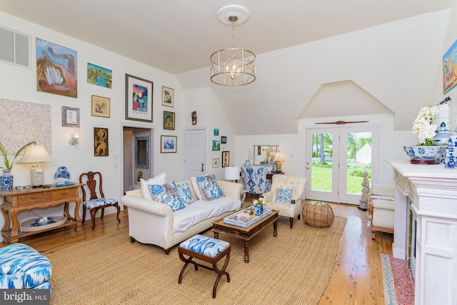 living room featuring high vaulted ceiling, french doors, a chandelier, and light wood-type flooring