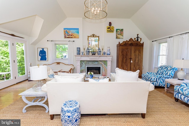 living room featuring hardwood / wood-style floors, plenty of natural light, a fireplace, and an inviting chandelier