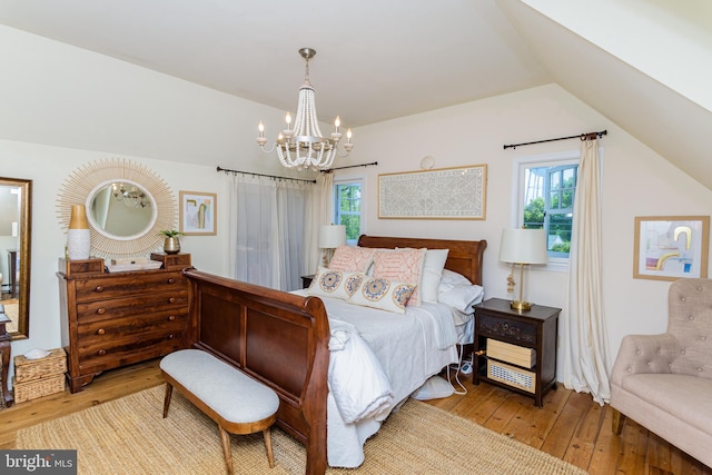 bedroom featuring wood-type flooring, a chandelier, and lofted ceiling