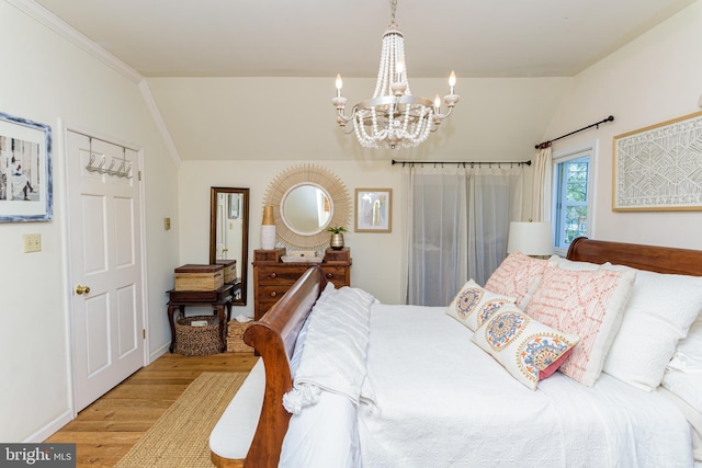 bedroom featuring wood-type flooring, lofted ceiling, crown molding, and a chandelier