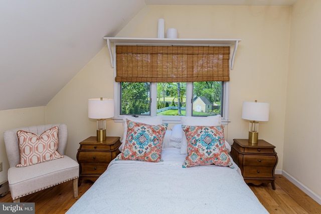 bedroom with wood-type flooring and lofted ceiling