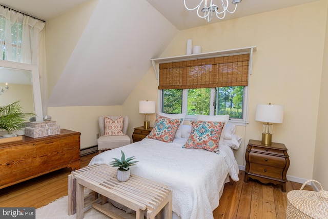 bedroom with vaulted ceiling, a chandelier, hardwood / wood-style flooring, and a baseboard heating unit