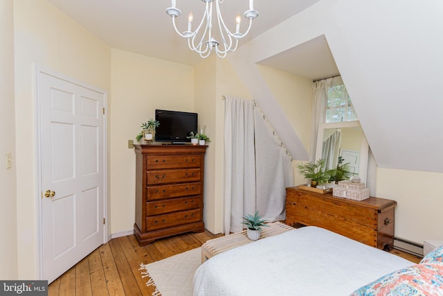 bedroom with a notable chandelier, a baseboard radiator, hardwood / wood-style flooring, and vaulted ceiling