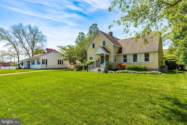 view of front of house featuring central AC and a front yard