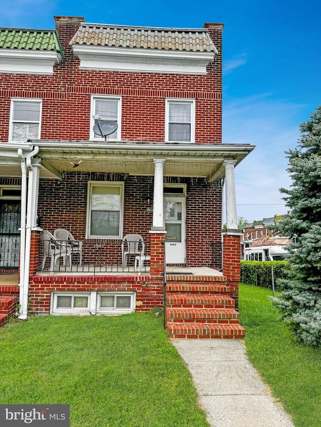 view of front of home with covered porch and a front lawn