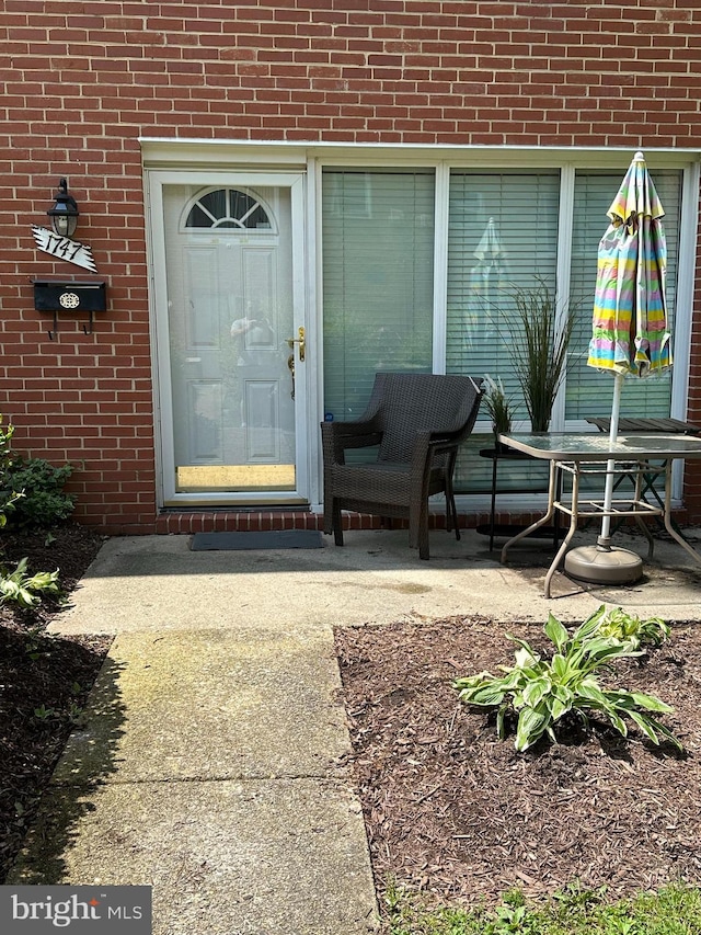 view of exterior entry with a patio area