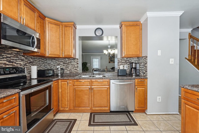 kitchen with ornamental molding, sink, a chandelier, appliances with stainless steel finishes, and decorative backsplash